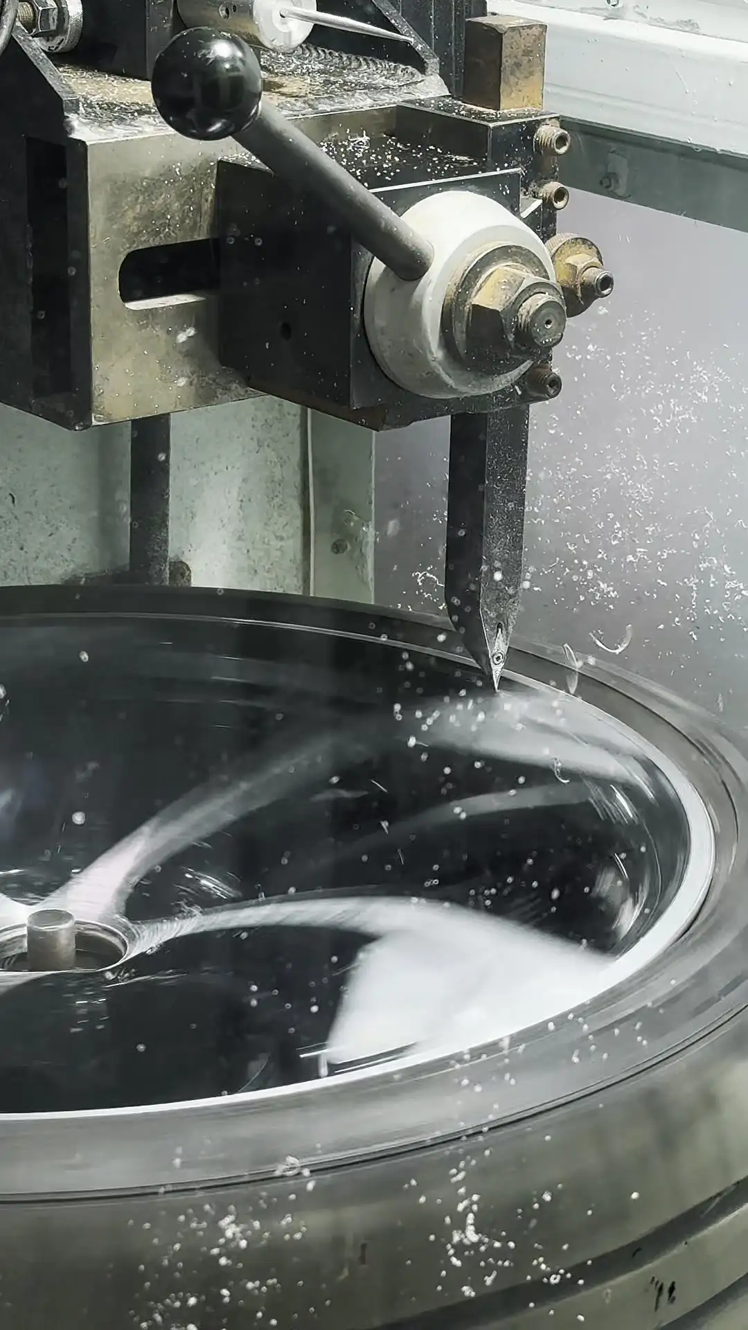 Precision machine working on a metal wheel surface in the shop